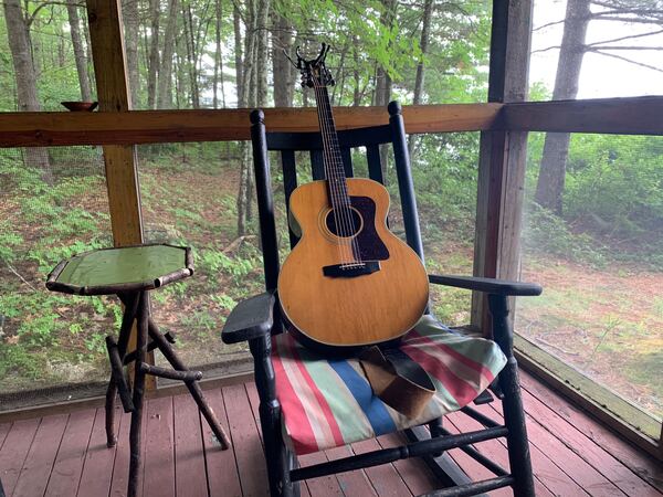 Jims guitar on rocking chair on porch